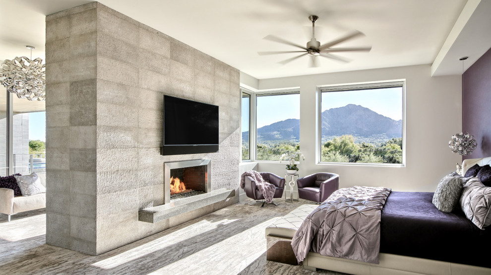 На фото: огромная хозяйская спальня в стиле модернизм с белыми стенами, ковровым покрытием, двусторонним камином, фасадом камина из металла и серым полом с