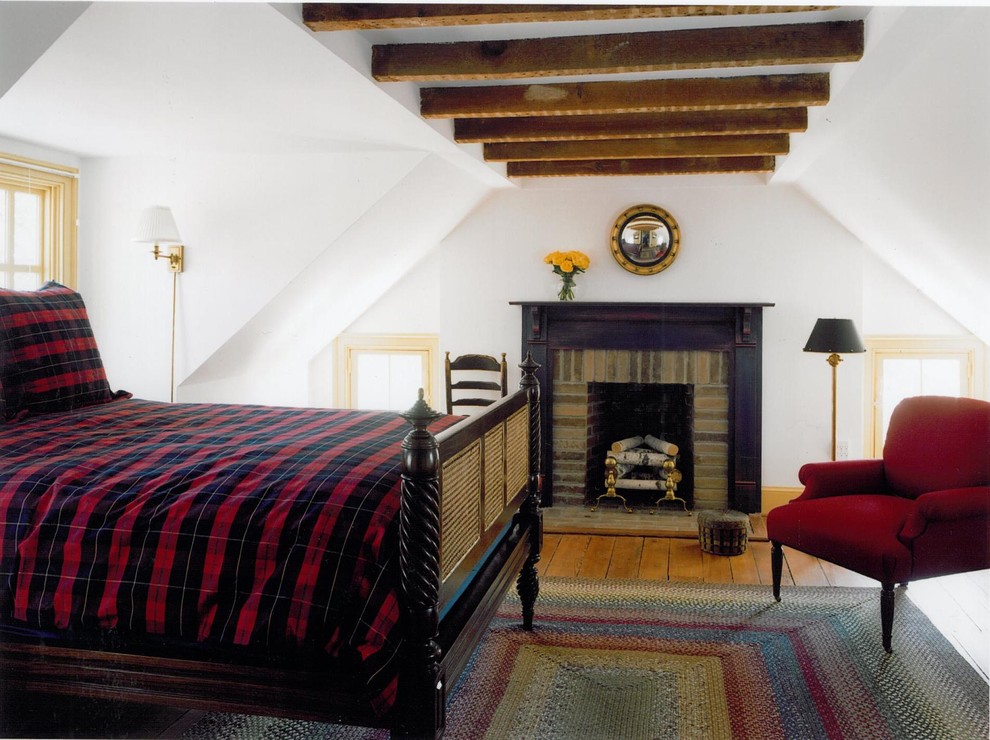Imagen de dormitorio clásico con paredes blancas, suelo de madera en tonos medios, todas las chimeneas y marco de chimenea de ladrillo