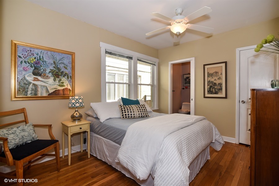 Medium sized classic guest bedroom in Chicago with yellow walls and medium hardwood flooring.