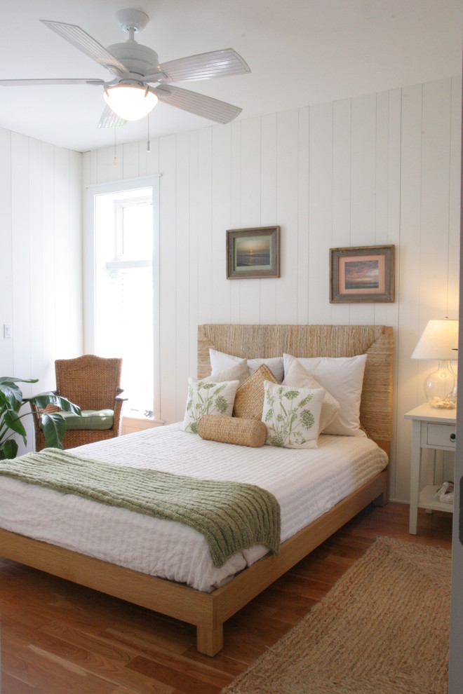 Diseño de habitación de invitados costera de tamaño medio con paredes blancas y suelo de madera en tonos medios