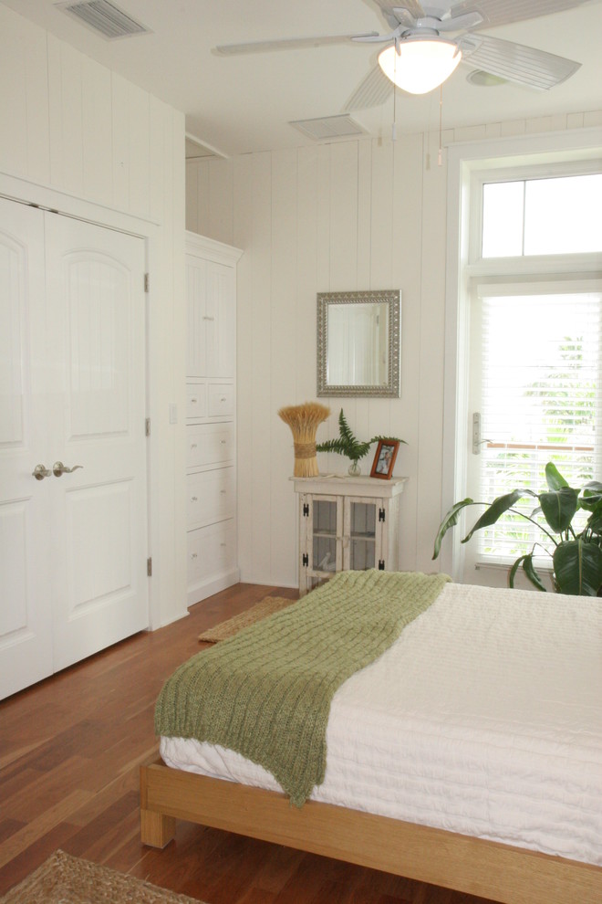 This is an example of a medium sized nautical guest bedroom in Tampa with white walls and medium hardwood flooring.