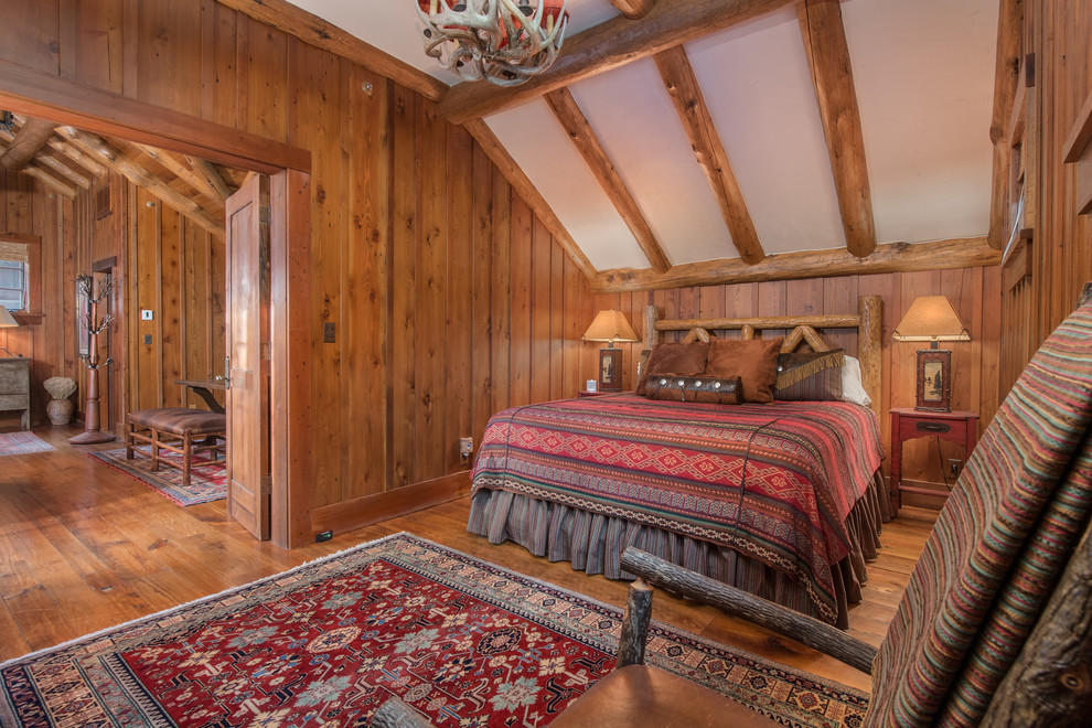 Imagen de dormitorio rural con paredes marrones, suelo de madera en tonos medios y suelo marrón