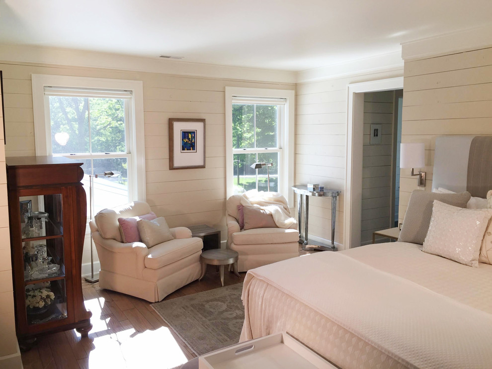 Immagine di una grande camera matrimoniale country con pareti beige e pavimento in legno massello medio