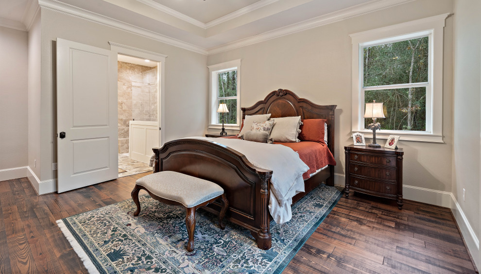 Exempel på ett sovrum, med beige väggar, mörkt trägolv och brunt golv