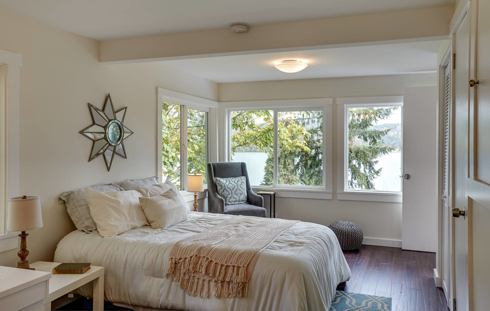 Modelo de dormitorio clásico renovado con paredes beige, suelo de madera oscura y suelo marrón
