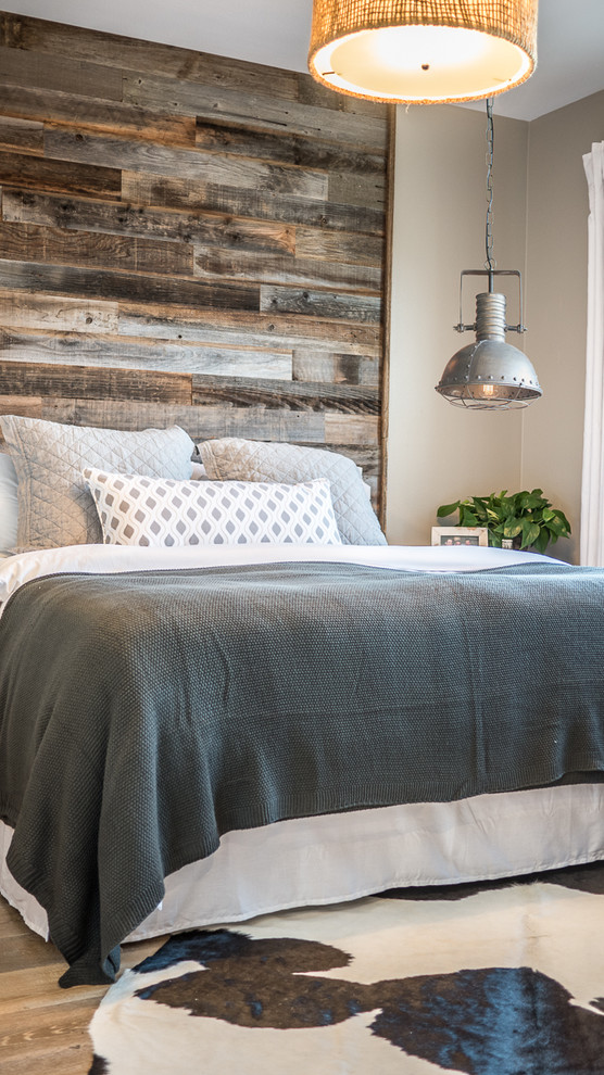 Modelo de dormitorio principal rústico de tamaño medio con paredes beige y suelo de madera en tonos medios