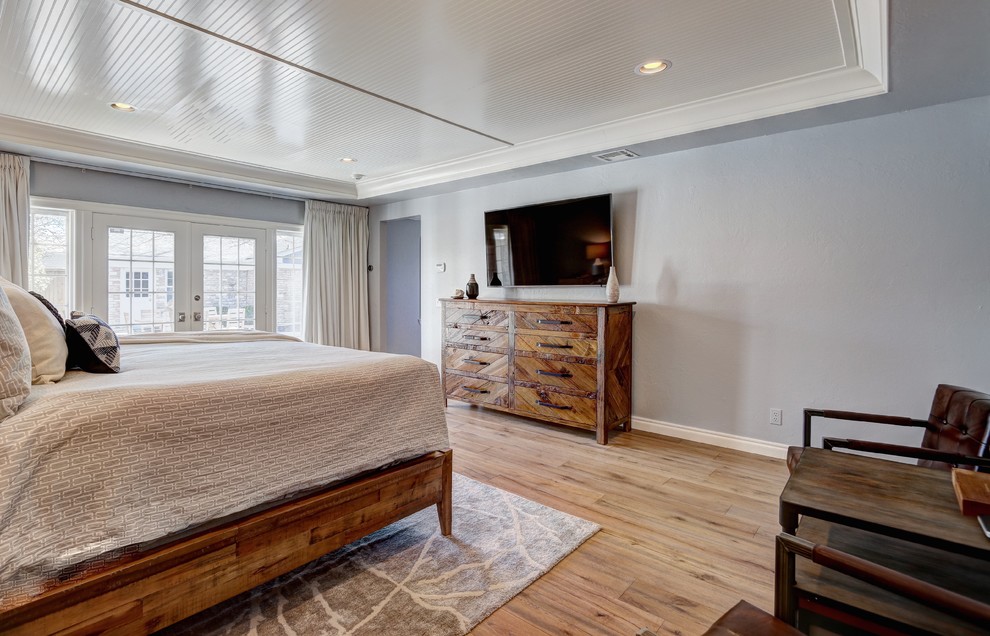 Foto de dormitorio tradicional renovado grande sin chimenea con paredes azules y suelo de madera clara
