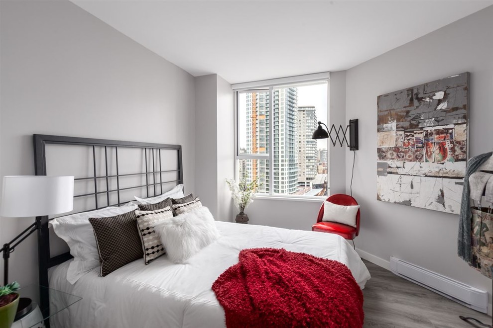 This is an example of a medium sized industrial guest bedroom in Vancouver with grey walls, medium hardwood flooring, no fireplace and beige floors.