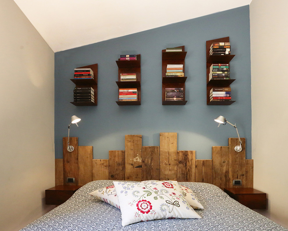 This is an example of a small industrial master bedroom in Florence with blue walls.