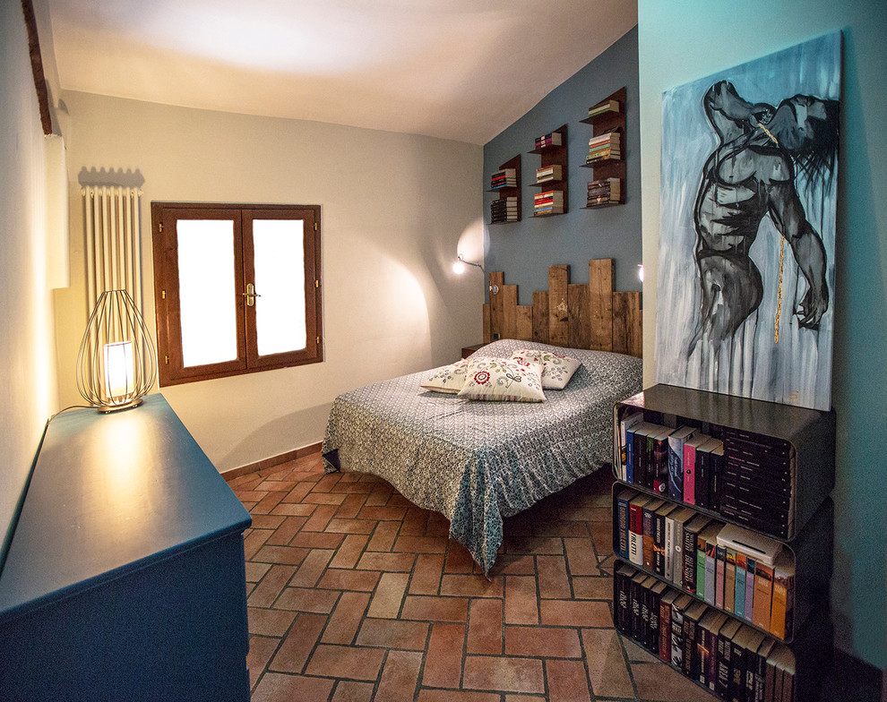 Foto di una piccola camera matrimoniale contemporanea con pareti blu e pavimento in terracotta