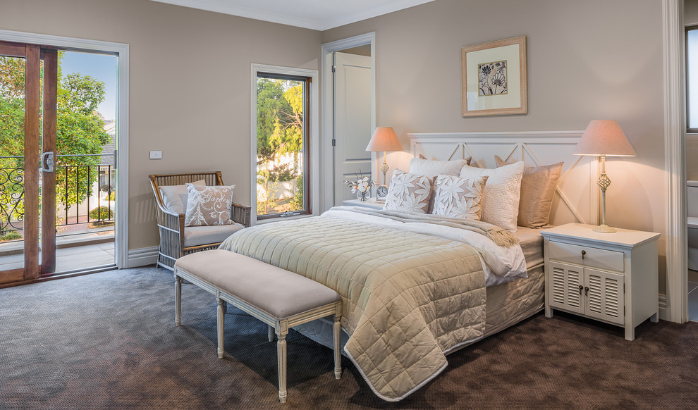 Large traditional bedroom in Melbourne with beige walls and carpet.