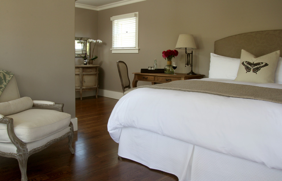 Aménagement d'une chambre parentale classique de taille moyenne avec un mur beige et un sol en bois brun.