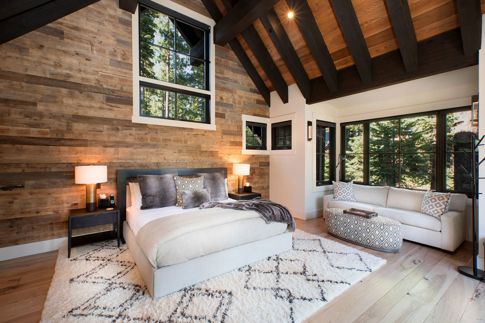 This is an example of a large rustic guest bedroom in Other with white walls, medium hardwood flooring and brown floors.