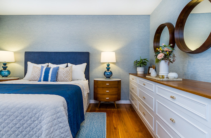 Diseño de dormitorio principal tradicional renovado grande con paredes azules, suelo de madera en tonos medios, papel pintado y suelo marrón