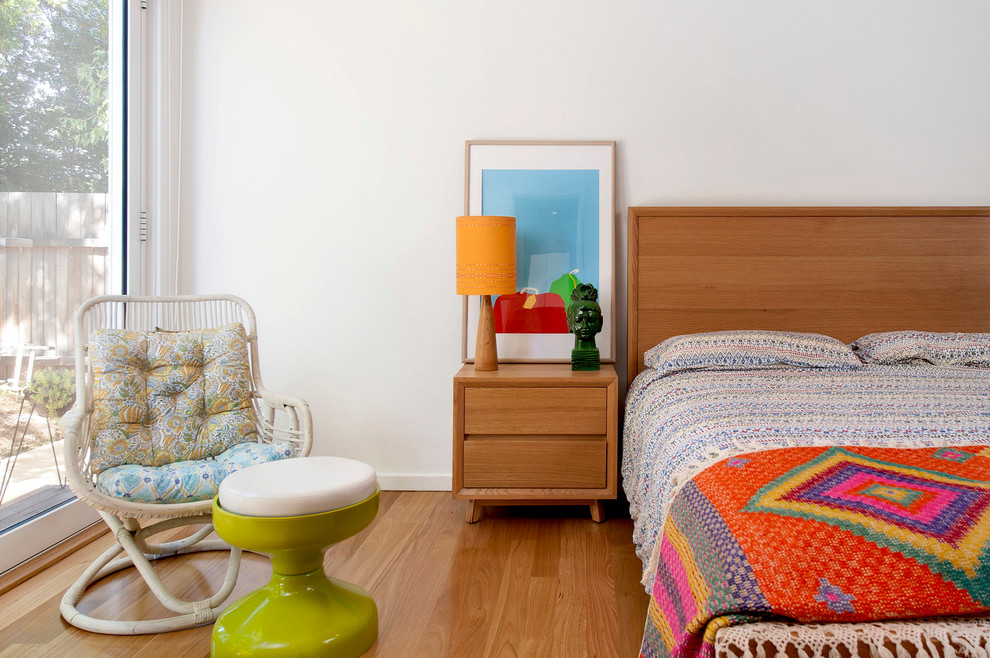 Diseño de habitación de invitados retro pequeña con paredes blancas y suelo de madera clara