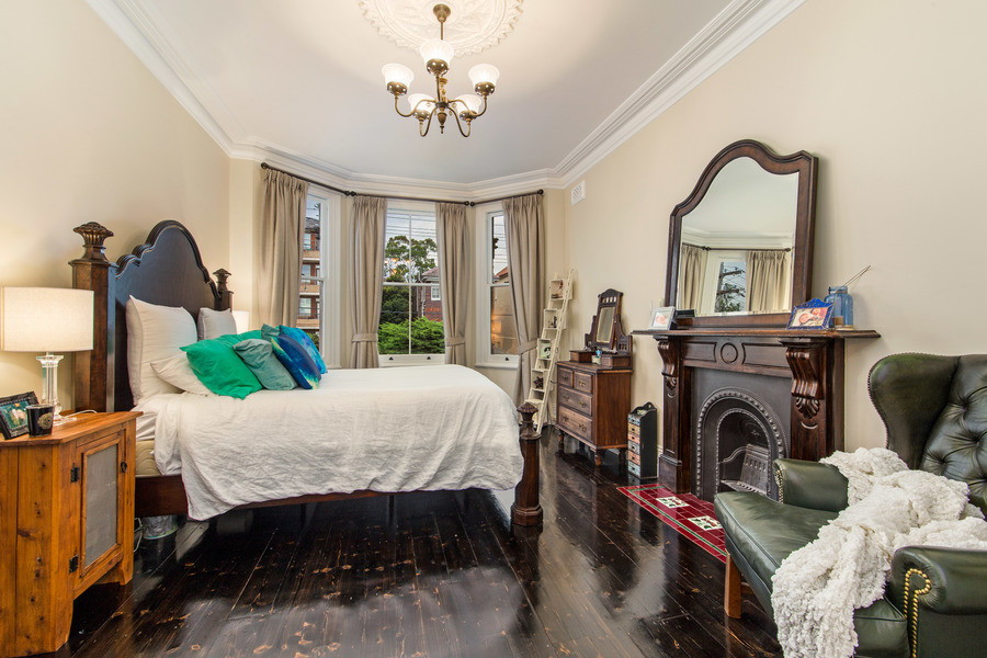 シドニーにある中くらいなヴィクトリアン調のおしゃれな主寝室 (ベージュの壁、濃色無垢フローリング、標準型暖炉、木材の暖炉まわり) のレイアウト