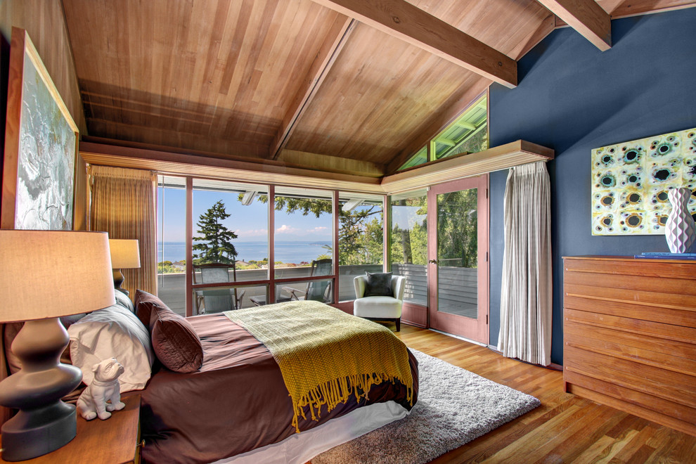 Modelo de dormitorio vintage con paredes azules y suelo de madera en tonos medios