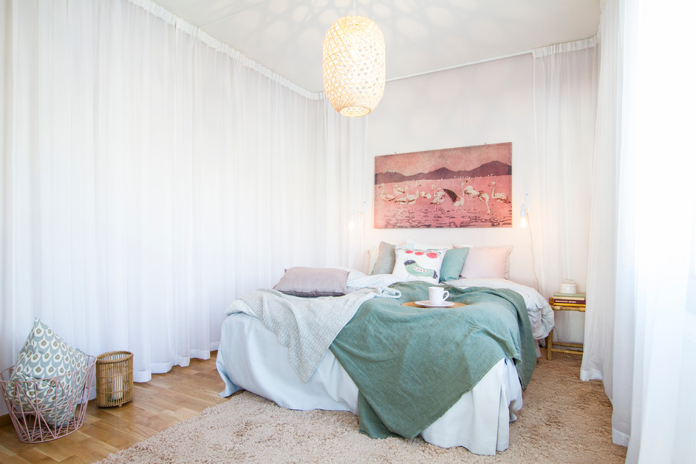 Foto de dormitorio principal nórdico grande sin chimenea con paredes blancas y suelo de madera en tonos medios