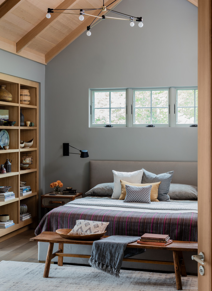Ejemplo de dormitorio principal y abovedado tradicional renovado sin chimenea con paredes grises, suelo de madera en tonos medios, suelo marrón, vigas vistas y madera