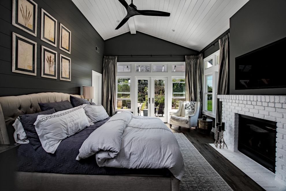 На фото: хозяйская спальня среднего размера в стиле кантри с серыми стенами, темным паркетным полом, стандартным камином, фасадом камина из кирпича и черным полом