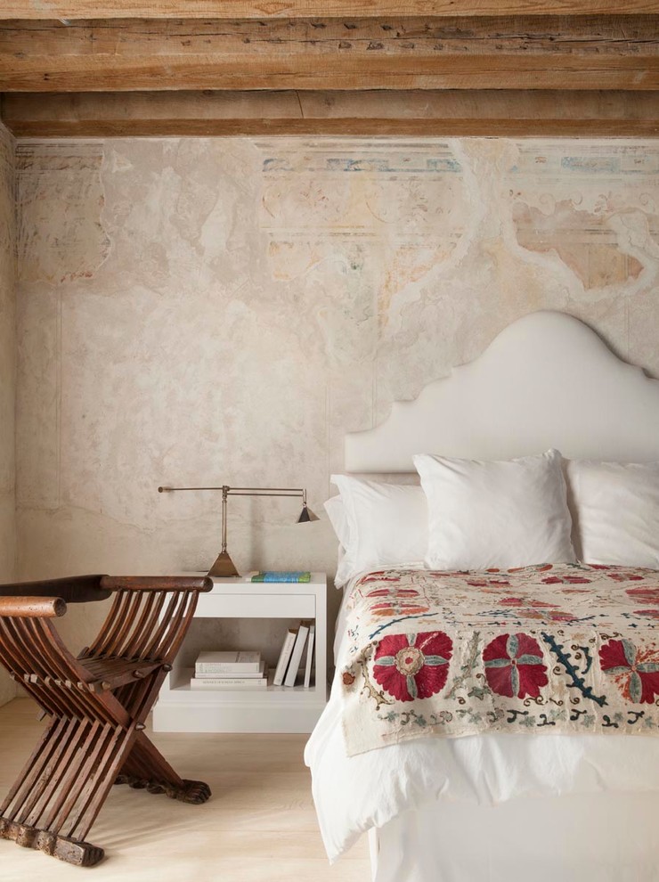 Modelo de dormitorio mediterráneo grande con paredes beige y suelo de madera clara