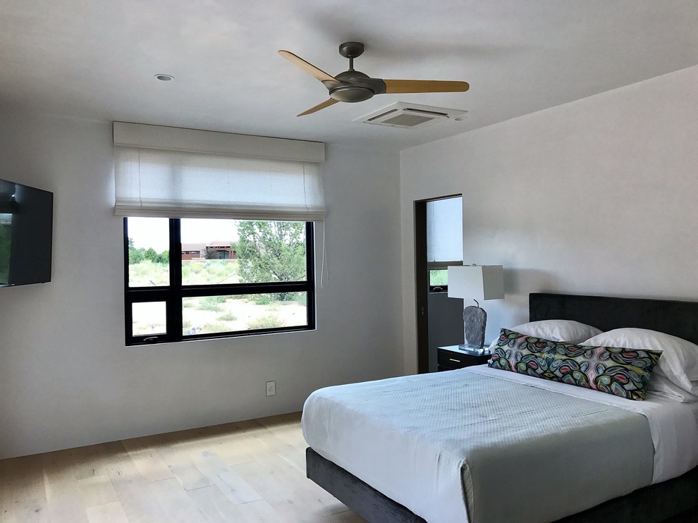 Ejemplo de dormitorio principal tradicional renovado de tamaño medio sin chimenea con paredes grises, suelo de madera clara y suelo negro