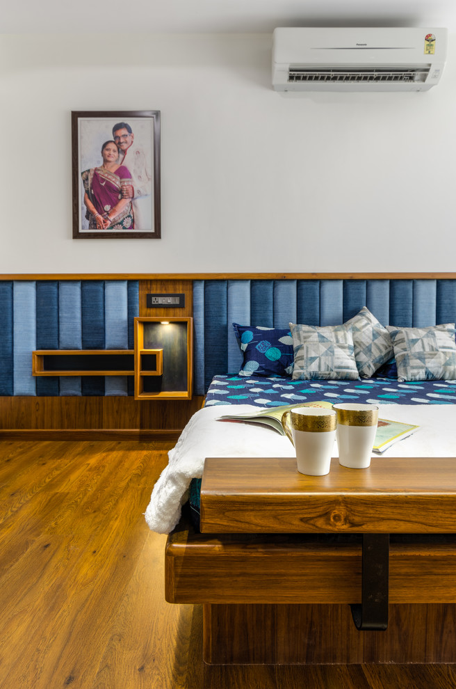 Foto di una camera da letto etnica con pareti bianche, pavimento in legno massello medio e pavimento marrone