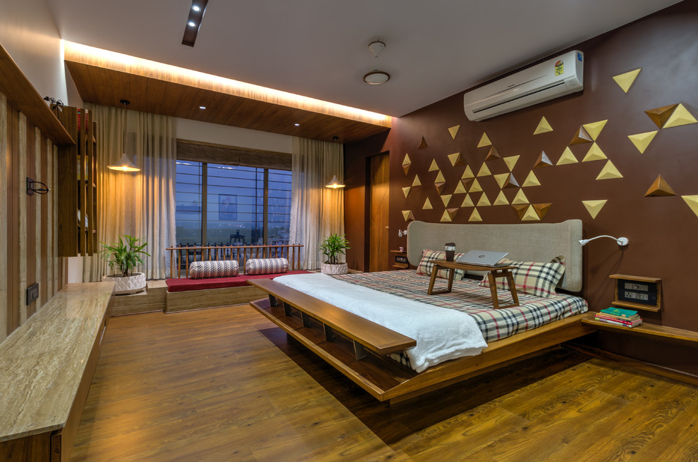 Foto på ett orientaliskt sovrum, med bruna väggar, mörkt trägolv och brunt golv