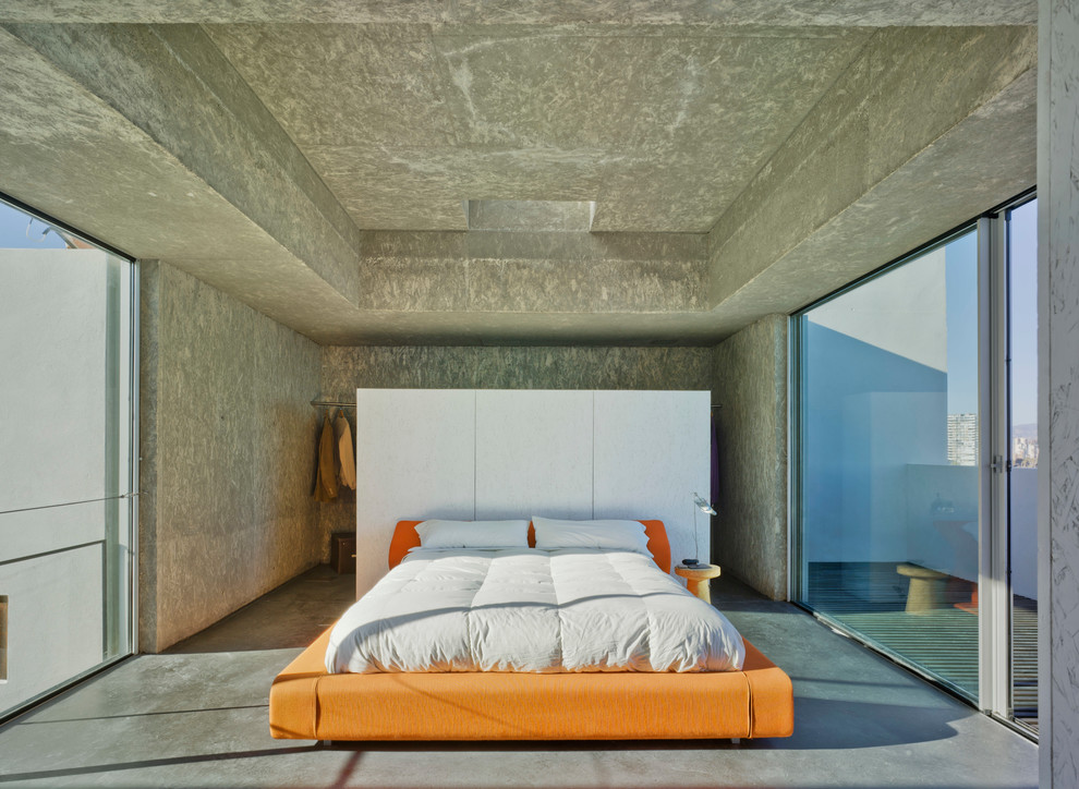 Inredning av ett industriellt sovrum, med betonggolv