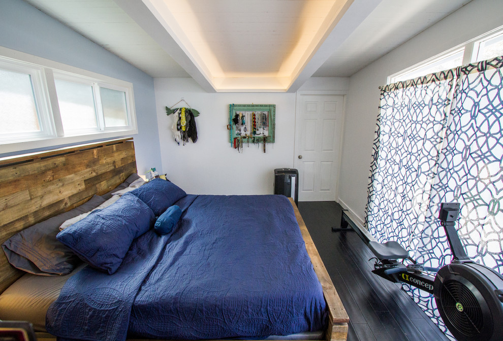 Mittelgroßes Modernes Schlafzimmer ohne Kamin mit blauer Wandfarbe, Vinylboden und schwarzem Boden in Orange County