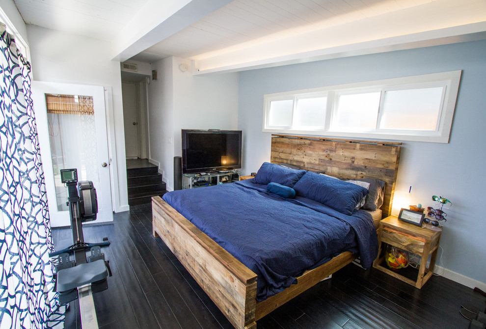Immagine di una camera da letto design di medie dimensioni con pareti blu, pavimento in vinile, nessun camino e pavimento nero