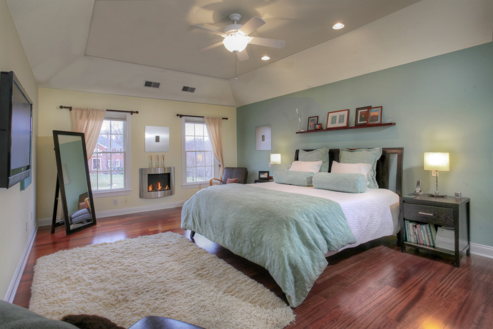 Cette photo montre une chambre parentale éclectique de taille moyenne avec un mur vert, parquet foncé et une cheminée ribbon.