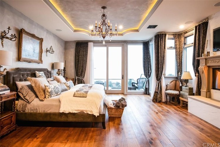 Bedroom - large traditional master dark wood floor and brown floor bedroom idea in Phoenix with gray walls, a standard fireplace and a stone fireplace