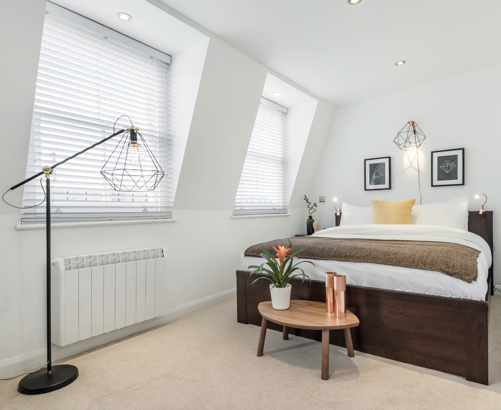 Contemporary loft bedroom in London with white walls and carpet.