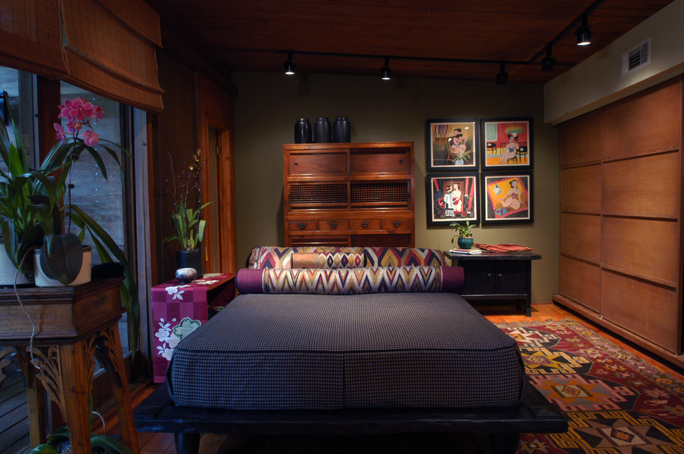 Ejemplo de dormitorio principal asiático de tamaño medio sin chimenea con paredes verdes, suelo de madera en tonos medios y suelo marrón