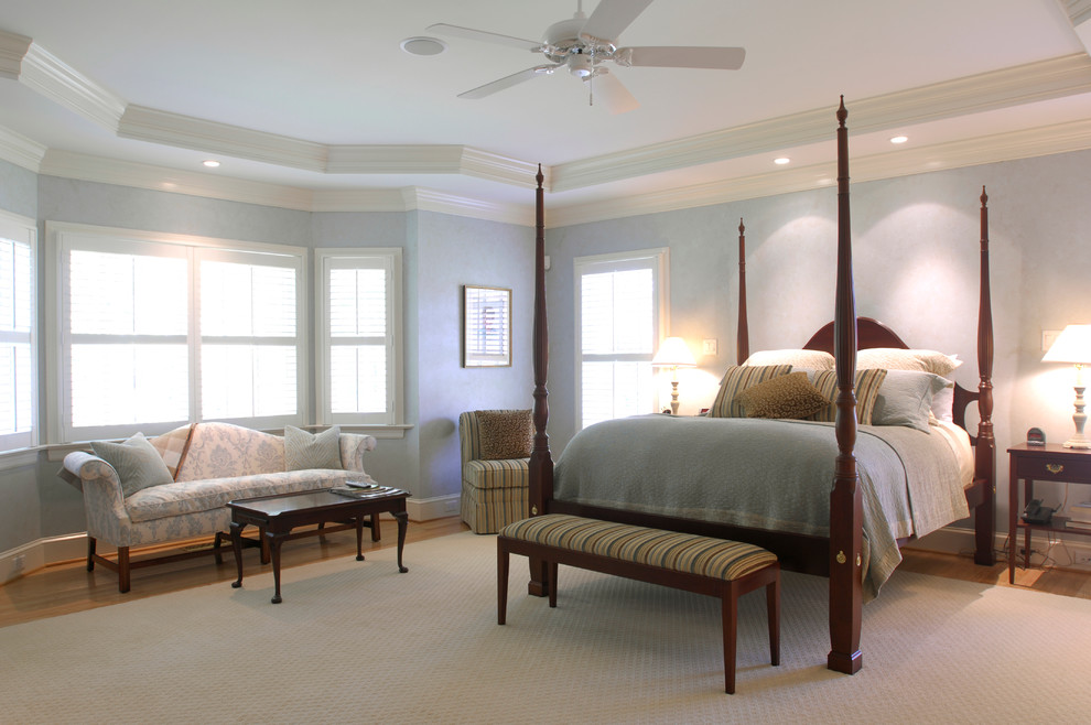 Imagen de dormitorio principal clásico renovado grande sin chimenea con paredes azules y suelo de madera clara