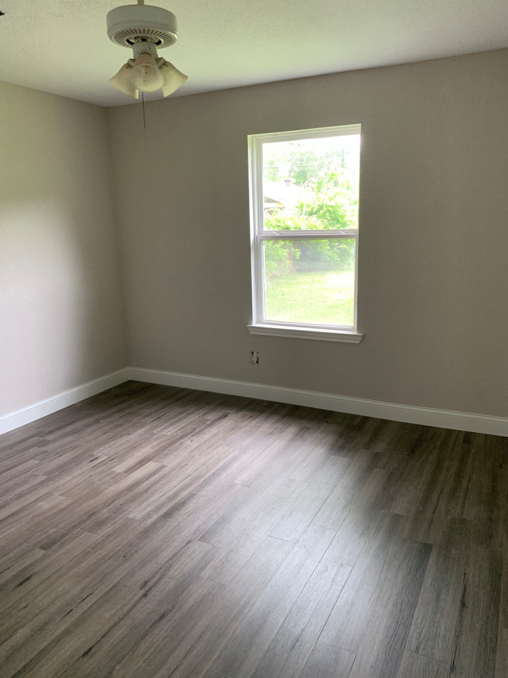 Mittelgroßes Modernes Gästezimmer mit grauer Wandfarbe, Vinylboden und grauem Boden in Houston
