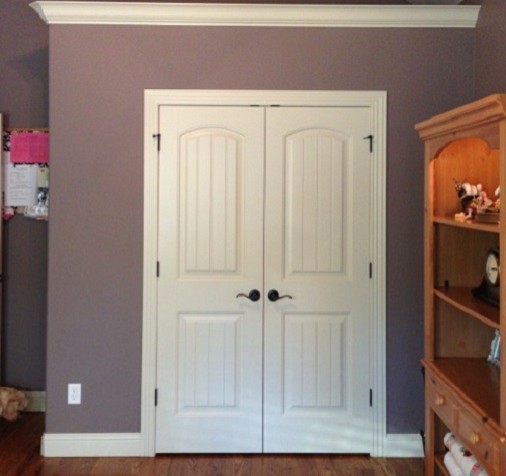 Exemple d'une chambre de taille moyenne avec un mur violet et un sol en bois brun.