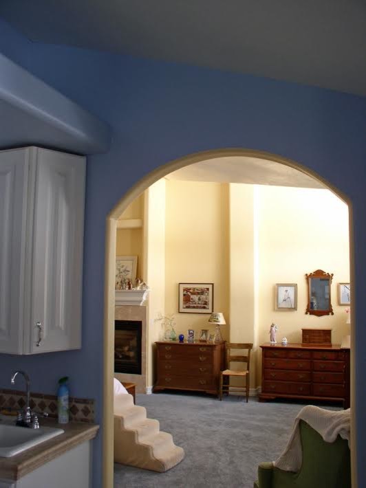 На фото: хозяйская спальня среднего размера в классическом стиле с желтыми стенами, ковровым покрытием, стандартным камином и фасадом камина из плитки с