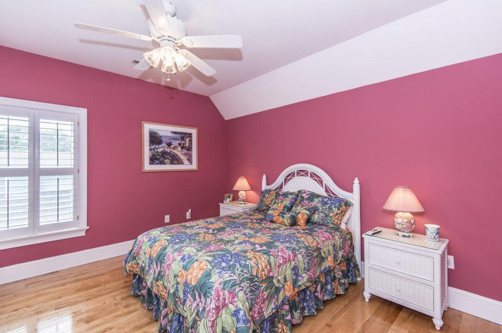 Foto de habitación de invitados marinera grande sin chimenea con paredes rosas, suelo de madera clara y suelo marrón