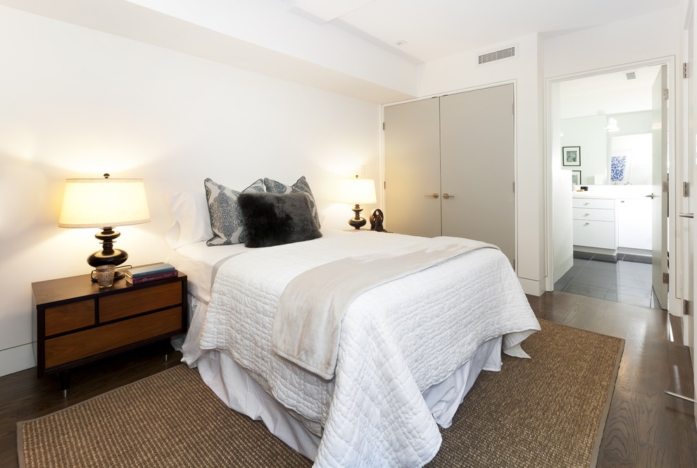 Modelo de habitación de invitados contemporánea de tamaño medio sin chimenea con paredes blancas, suelo de madera oscura y suelo marrón