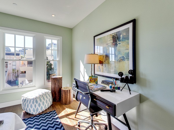 Ejemplo de habitación de invitados contemporánea de tamaño medio con paredes verdes y suelo de madera clara
