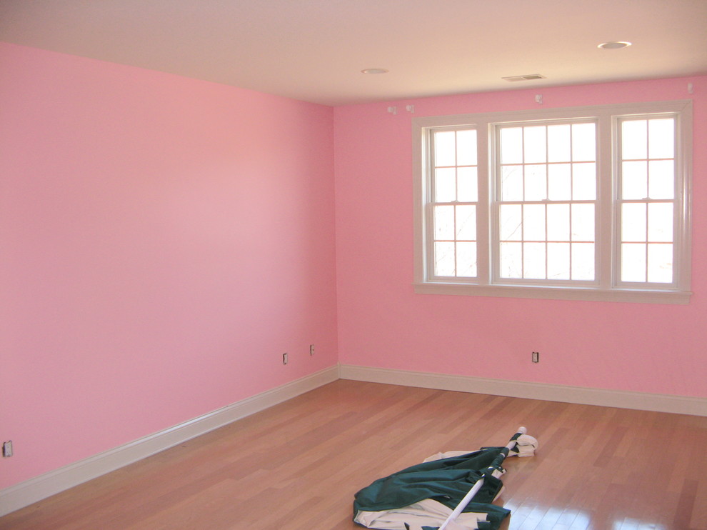 Modelo de habitación de invitados clásica renovada de tamaño medio sin chimenea con paredes rosas, suelo de madera clara y suelo marrón