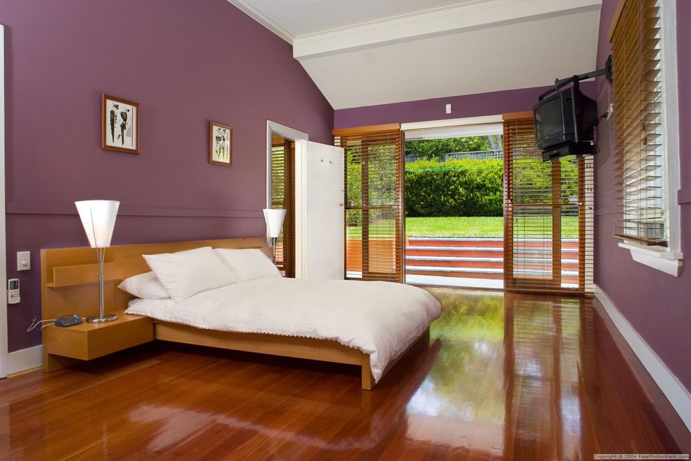 Idées déco pour une chambre parentale classique de taille moyenne avec un mur rose, un sol en bois brun et un sol marron.