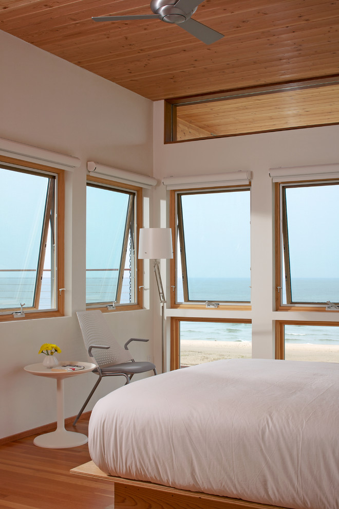 Diseño de dormitorio actual de tamaño medio con suelo de madera en tonos medios