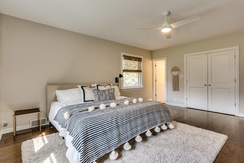 Ejemplo de dormitorio clásico renovado con paredes beige, suelo de madera en tonos medios y suelo marrón
