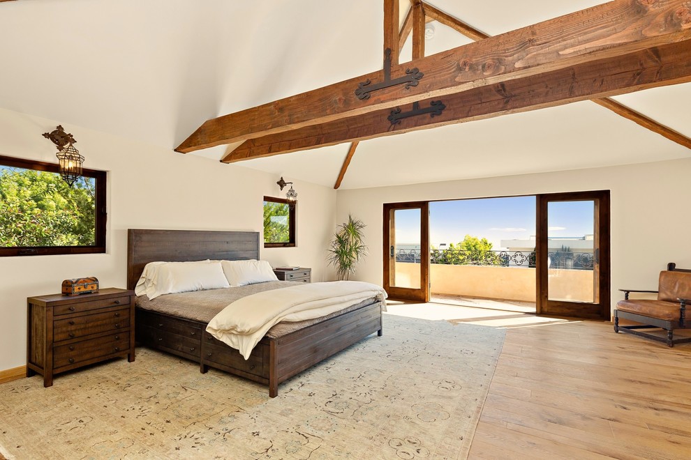 Inspiration for a mediterranean light wood floor and beige floor bedroom remodel in Los Angeles with white walls