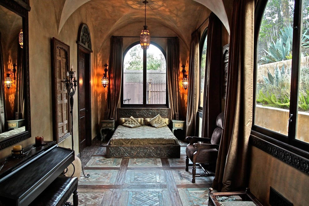 Modelo de dormitorio mediterráneo con paredes marrones, suelo de madera en tonos medios y suelo marrón