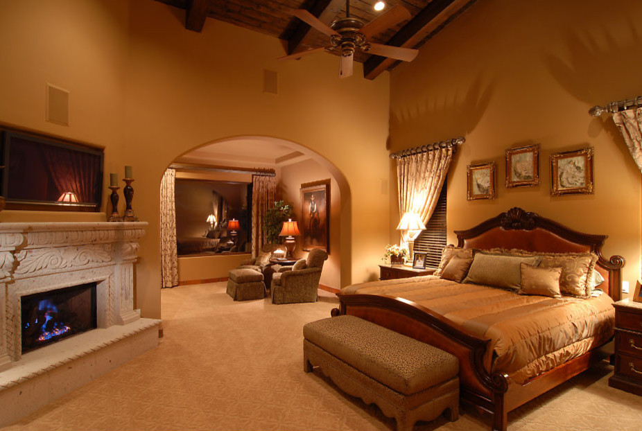 Inspiration for a huge timeless master carpeted and beige floor bedroom remodel in Phoenix with yellow walls, a standard fireplace and a plaster fireplace