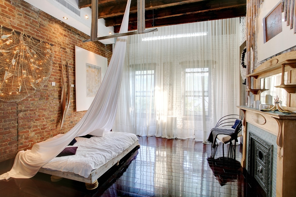 Foto di una camera da letto industriale con cornice del camino piastrellata e camino classico